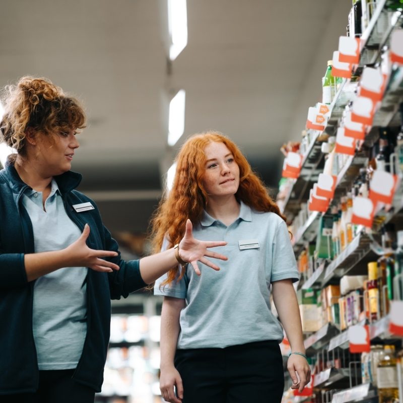 Supermarktangestellte schauen auf ein Regal